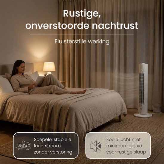 Een vrouw leest een boek in bed, naast een witte JAP torenventilator die zachtjes lucht blaast.