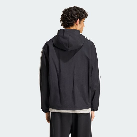 Achterkant van zwart Adidas windjack met capuchon, witte strepen op de mouwen en grijze onderlaag.