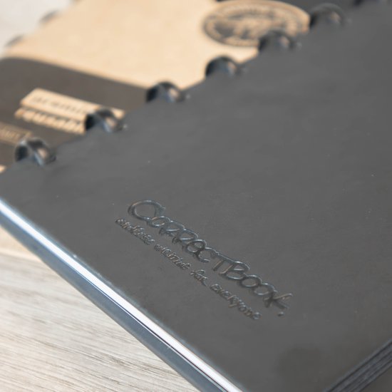 Close-up van een deel van een zwart Correctbook notitieboek met de tekst 'Correctbook' ingeperst.
