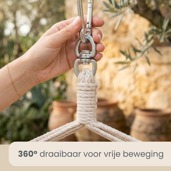 Hand die metalen karabijnhaak en touwen van een hangstoel vastpakt.