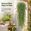 Hangplant met roze bloemen en groene bladeren, buiten bij een houten structuur. Tekst: 'Natuurlijke sfeer in huis'.