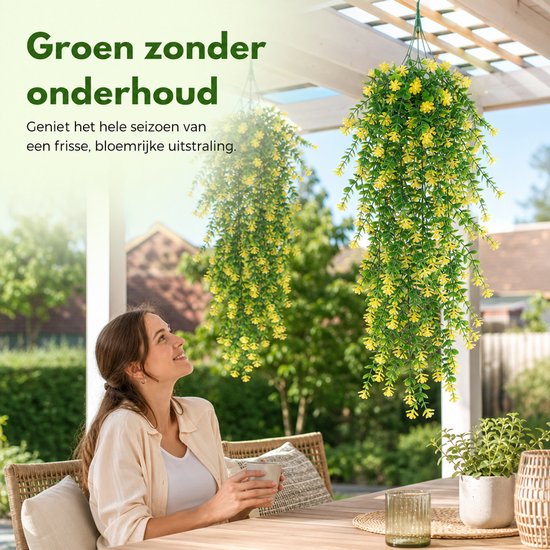 Vrouwen genieten van twee hangende kunstplanten met groene bladeren en gele bloemen onder een pergola.