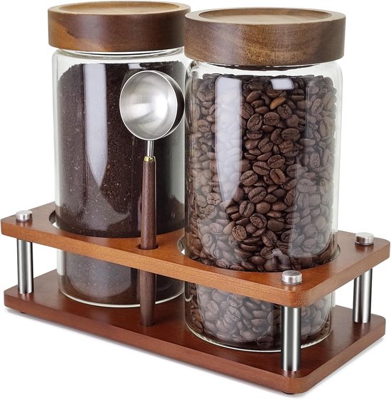 Deux pots de stockage en verre avec couvercles en bois et cuillères, remplis de café moulu et de grains de café.