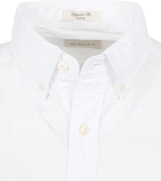 Detail van een wit katoenen overhemd met knoopjes en kraag, met 'Regular Fit' label.