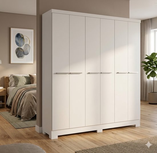 Strakke witte kledingkast met zes deuren en minimalistische handgrepen, naast een bed in een slaapkamer.