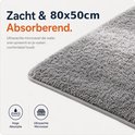 Close-up van een zachte, absorberende grijze badmat met microvezels. Afmeting 80x50cm.