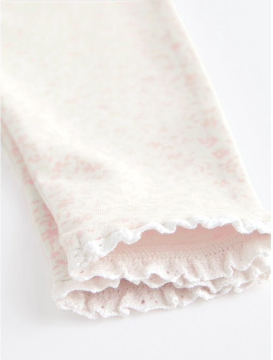 Close-up van de kanten rand van een roze legging met bloemenprint.