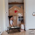 Man en kind spelen met knutselhuisje in een kast. Bedtafel met verf, telefoon en smartphone ernaast.
