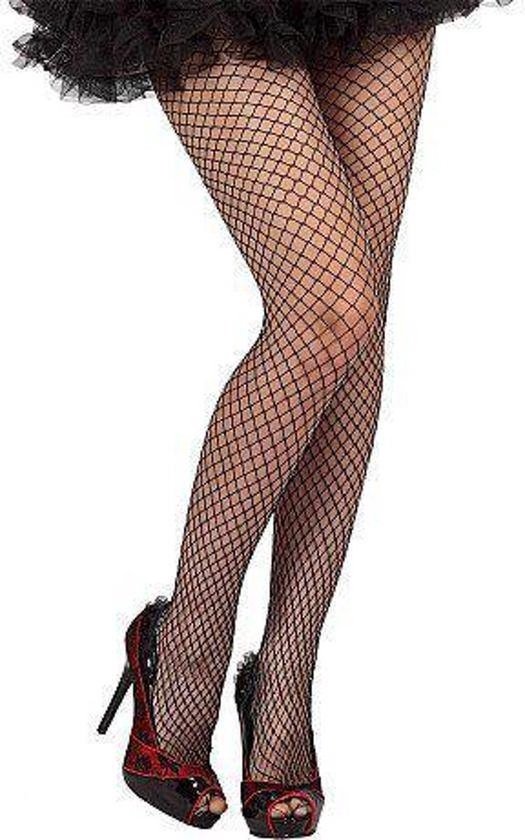 Zwarte visnetpanty met grof netpatroon, gedragen met open schoenen en zwarte rok.