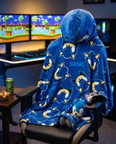 Een persoon zit in een gamestoel, gehuld in een blauwe flanellen deken met capuchon, bedrukt met Sonic the Hedgehog. Een Sonic knuffel ligt op de deken.