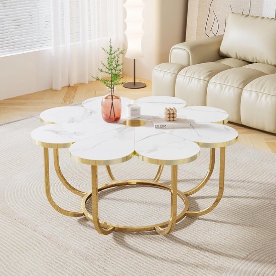 Bloemvormige salontafel met wit marmerlook tafelblad, gouden frame en kaars.