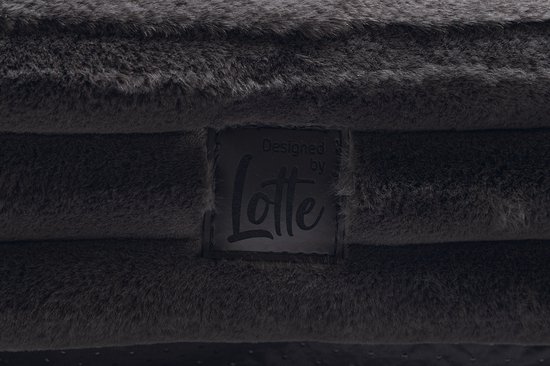 Een label met 'Designed by Lotte' op een donkergrijs, zacht hondenbed met ribbelstof.