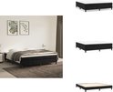 Zwart boxspringbed met witte matras, vierkante poten, gestoffeerde basis, in slaapkamer met planten en dekens.