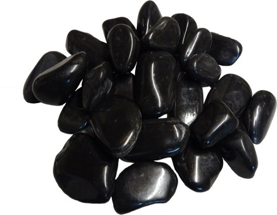 Une pile de galets noirs brillants et polis sur fond blanc.