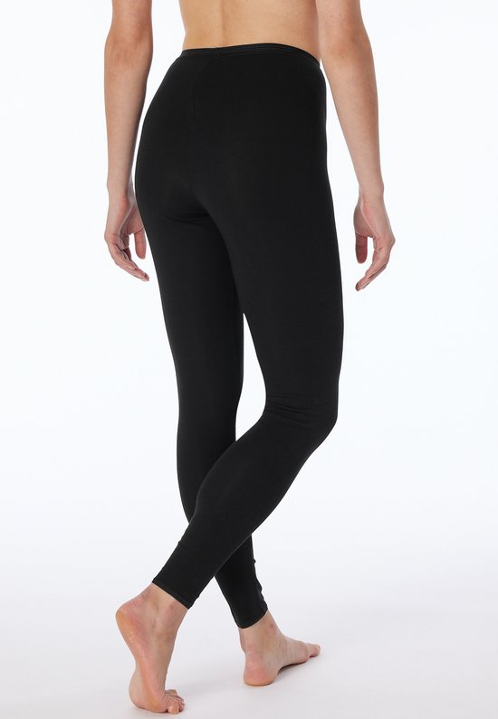 Zwart onderlichaam van een model dat een zwarte legging draagt.