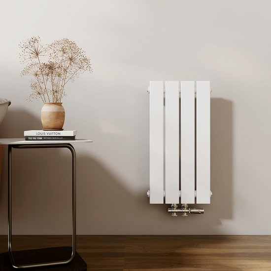 Slanke witte verticale radiator met vier platte panelen, naast een bijzettafel met een boek en een vaas met gedroogde bloemen.