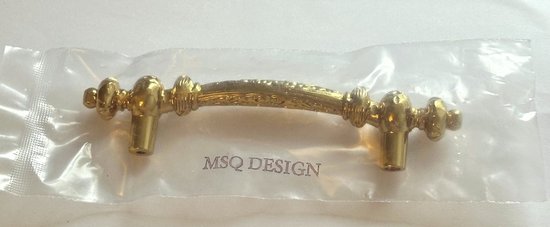 Gouden handgreep met decoratieve details, verpakt in plastic. De tekst MSQ DESIGN is zichtbaar.