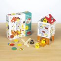 Doos met 'Happy Chickens' spel. Toont kippenhok, gele en zwarte kuikentjes, stokjes en schijfjes. Illustraties van moederkip en kuikens.