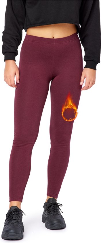 Een vrouw draagt een wijnrode thermische legging en zwarte sneakers.