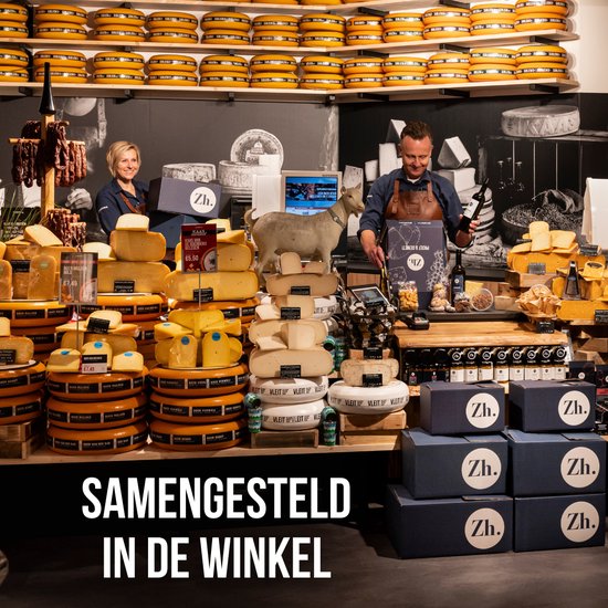 Twee medewerkers in een winkel vol kazen, een geit en de tekst 'SAMENGESTELD IN DE WINKEL'.