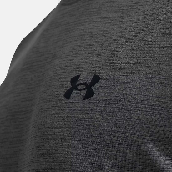 Detail van grijs sportshirt met fijne textuur, horizontaal streepmotief en zwart Under Armour logo.