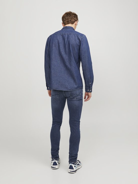 Achterkant van een man in een spijkerhemd en donkerblauwe jeans.