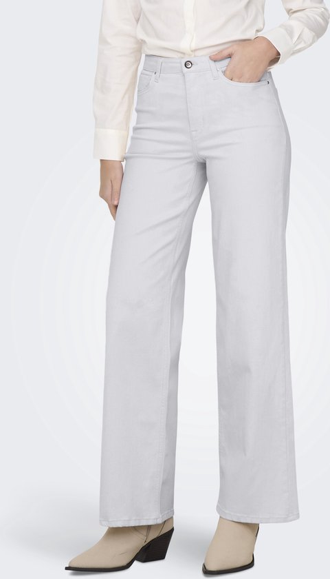Model in wijde, lichtgrijze jeans en een witte blouse.