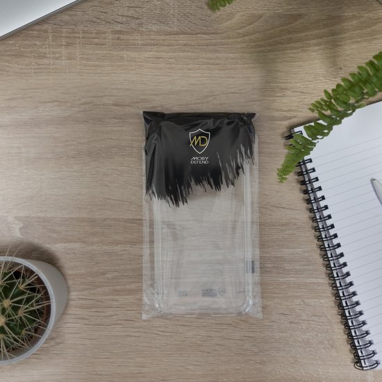 Verpakking van een doorzichtig telefoonhoesje met 'MobyDefend' logo, op een houten ondergrond.