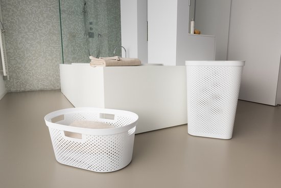 Twee witte wasmanden met ronde perforaties in een moderne badkamer.