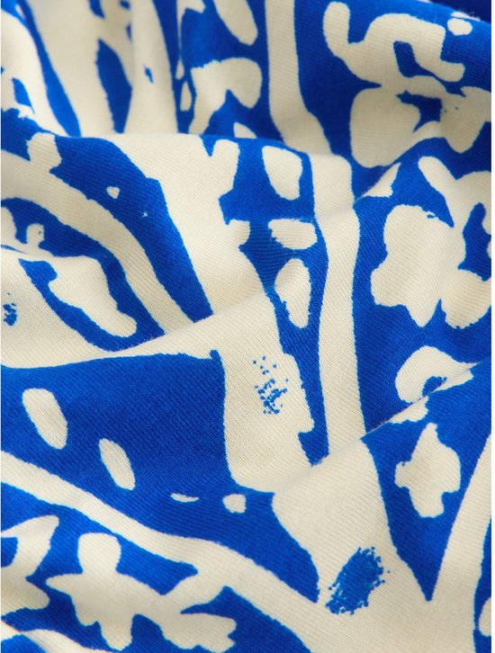 Crème broek met blauwe paisley print, gedetailleerd met textuur.