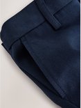 Detail van een donkerblauwe broek met een ceintuurlus en een steekzak.