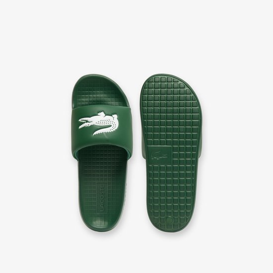 Donkergroene Lacoste slippers, bovenkant met witte krokodil, onderkant met rasterpatroon.