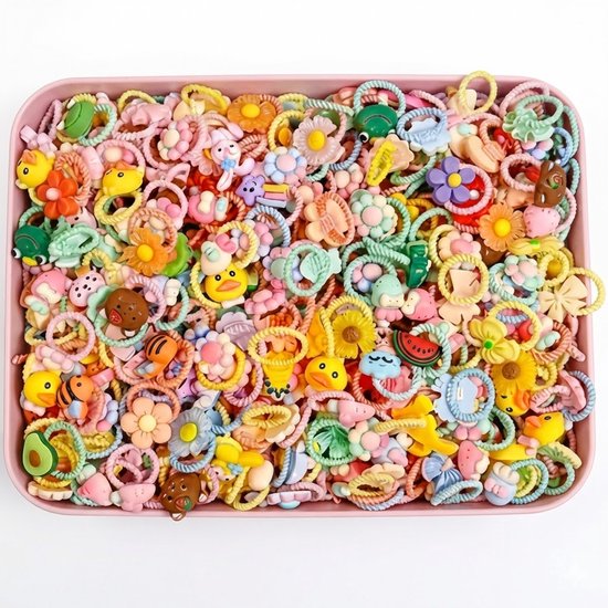 Roze bak met grote hoeveelheid kinder haar elastiekjes met figuurtjes van bloemen, dieren en fruit in pastelkleuren.