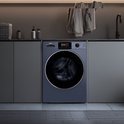 Lave-linge CHiQ bleu foncé dans une buanderie grise, avec plan de travail, panier et étendoir avec vêtements au-dessus.