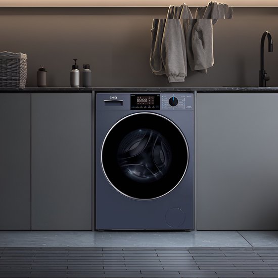 Lave-linge CHiQ bleu foncé dans une buanderie grise, avec plan de travail, panier et étendoir avec vêtements au-dessus.
