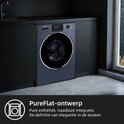 Lave-linge CHiQ bleu foncé avec 'PureFlat design' dans une cuisine, avec des placards noirs et une vue sur le jardin.