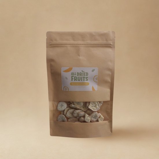 Bruine papieren zak met venster met gevriesdroogde bananenschijfjes en etiket 'ALL DRIED FRUITS Banana slices'.