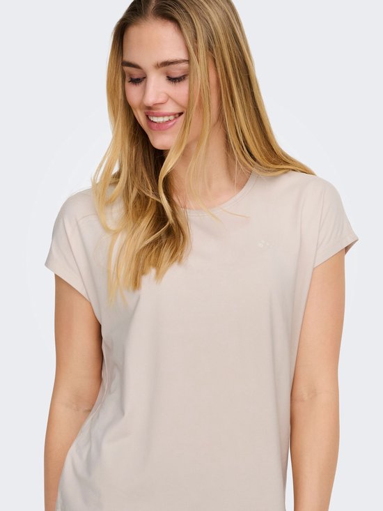 Close-up model in beige sportshirt met korte mouwen en logo op linkerborst.