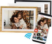 Een digitale fotolijst met een houten lijst, die een foto van een vrouw en kind voor een kerstboom toont. Een smartphone met de Frameo app is ernaast geplaatst.