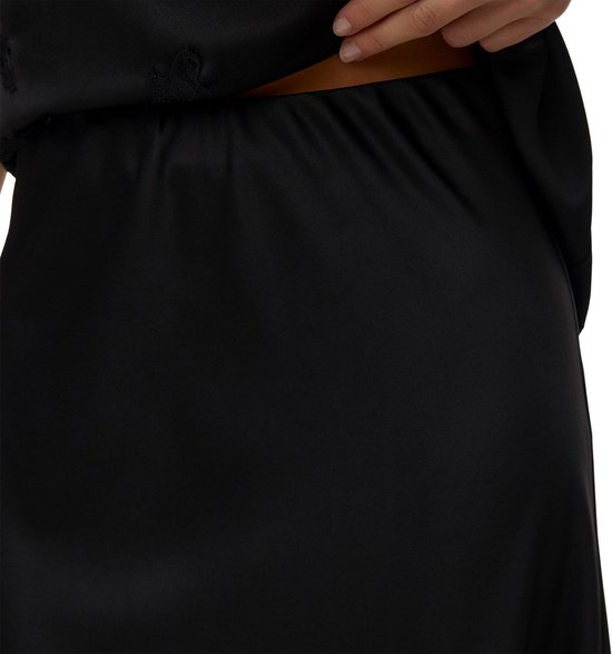 Femme portant une jupe en satin noir, gros plan de la taille.