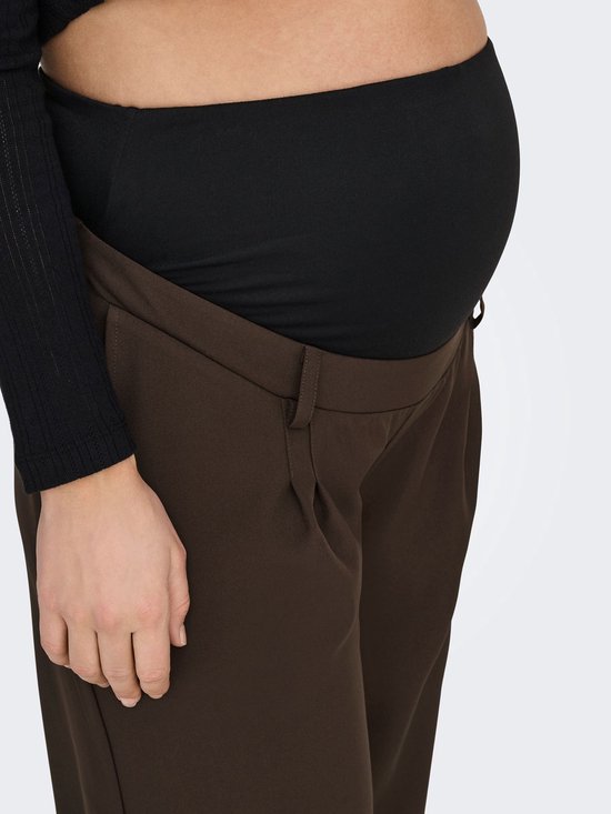 Close-up van de buik van een zwangere vrouw in een bruine broek.