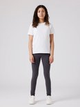 Een meisje met krullend haar in een witte t-shirt en antrgrijze legging.