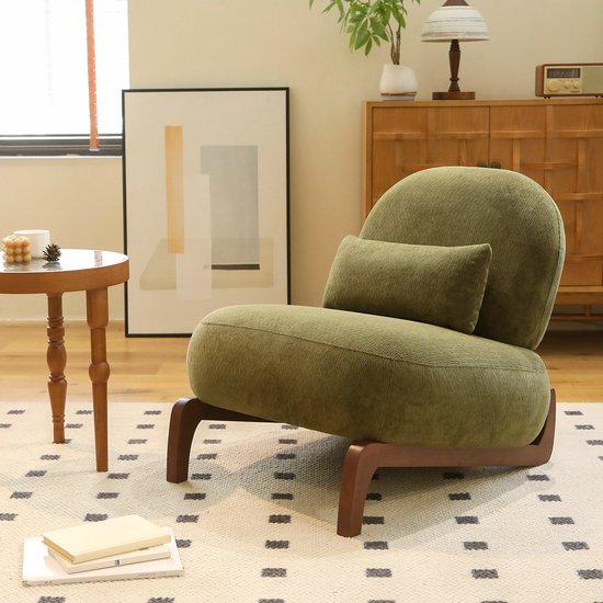 Fauteuil club vert avec dossier ergonomique et coussins moelleux, dans un salon élégant.