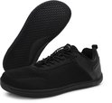 Zwarte lage sneaker met mesh en leren accenten, met de zool omhoog.