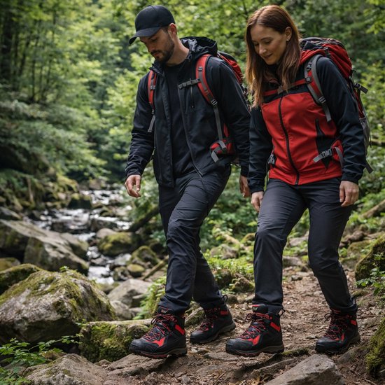 Man en vrouw wandelen in een bos, beide dragen wandelschoenen met rode en zwarte accenten.