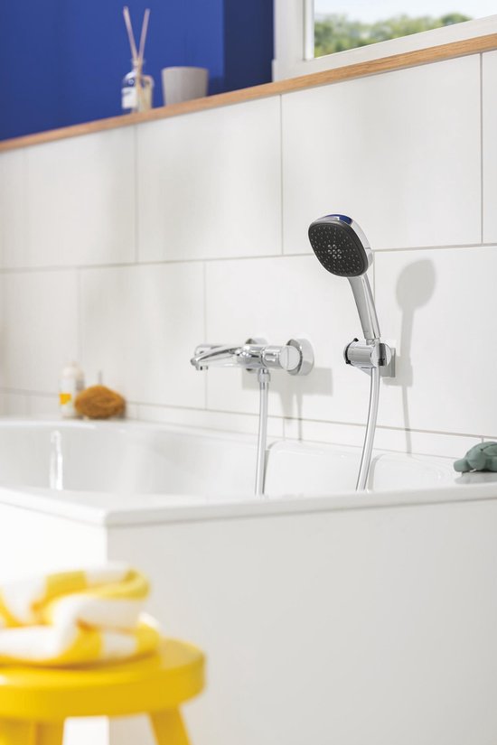 Bad met chroomkleurig douchesysteem, handdouche aan houder, met waterstralen.