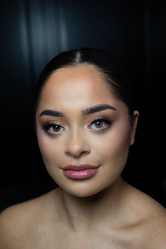 Vrouw met één bruin oog en één oog met een grijze contactlens voor een vergelijking.