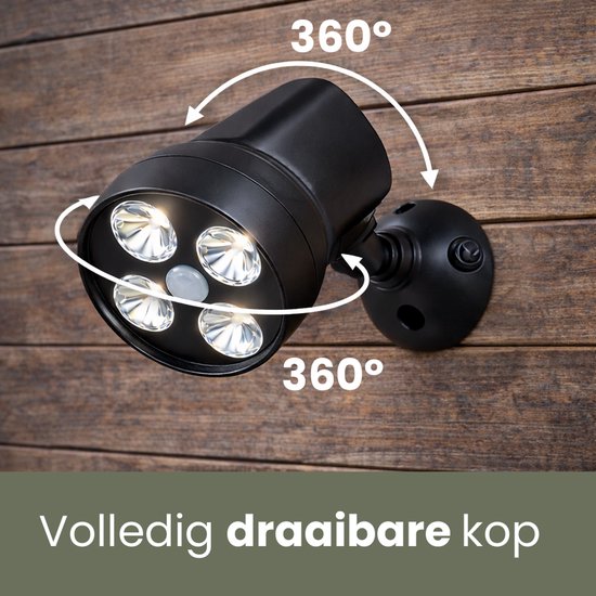 Zwarte buitenlamp met een volledig draaibare kop met vier LED-lampjes, gemonteerd op een houten schutting.