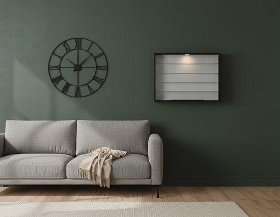 Zwarte vitrinekast met glazen deuren en verlichting, hangend aan een donkergroene muur boven een grijze bank.