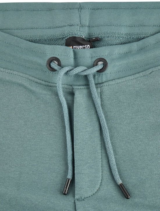 Trekkoord met metalen oogjes op een donkergroene joggingbroek.